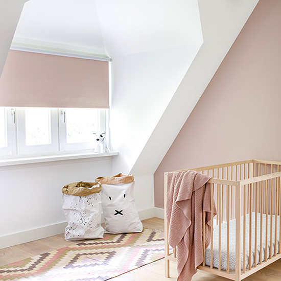 Roze verduisterend rolgordijn in de babykamer